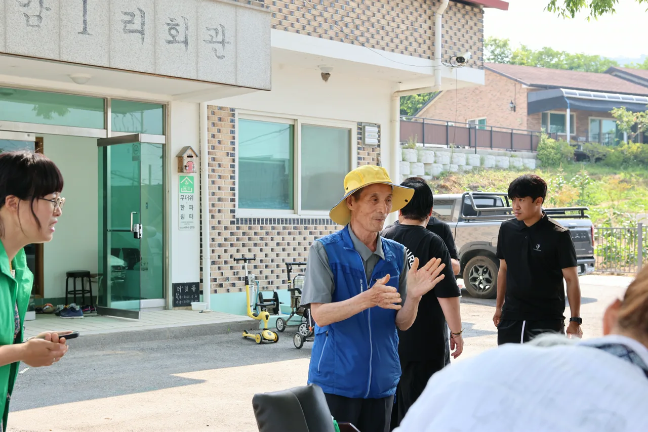 봉사 시작 전 마을에 도착해 장비를 내리며 모이는 회원들