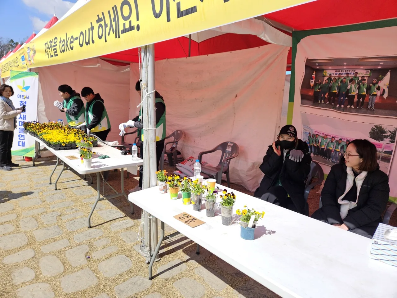 산수유축제 현장에 마련된 자원순환 다육이 나눔 부스와 초록 조끼를 입은 회원들